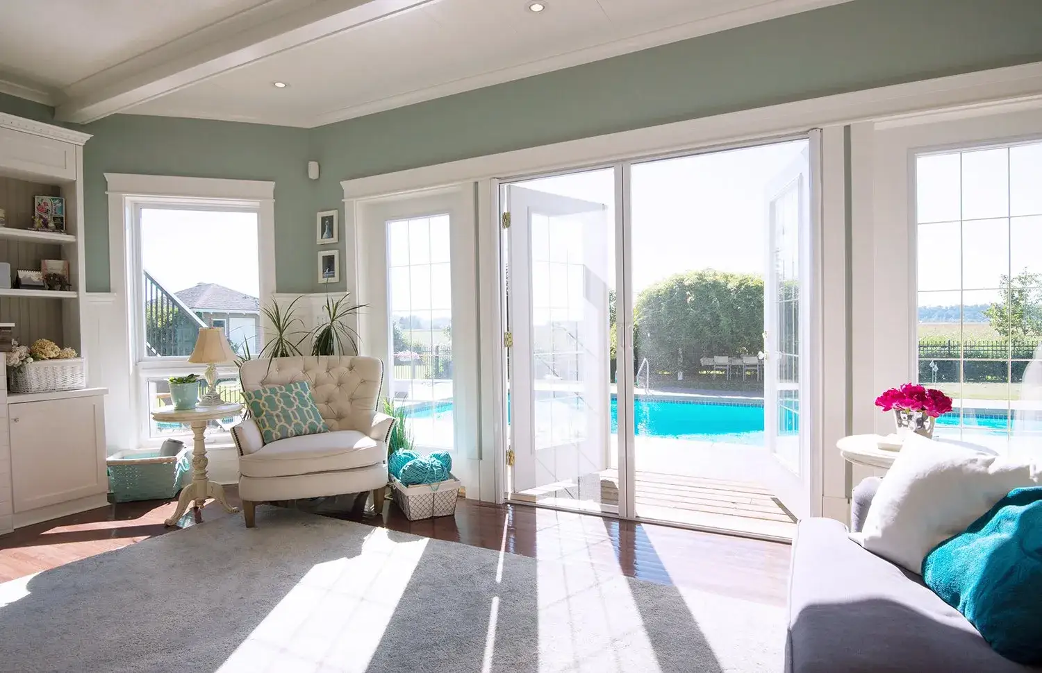 A retractable pleated door screen fitted across a deck opening, with a Phantom Screens van in the driveway beyond