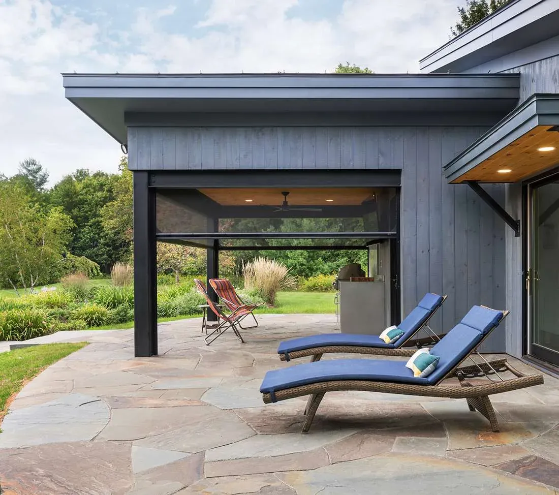 Executive motorised screens enclosing a covered patio beside a lawn