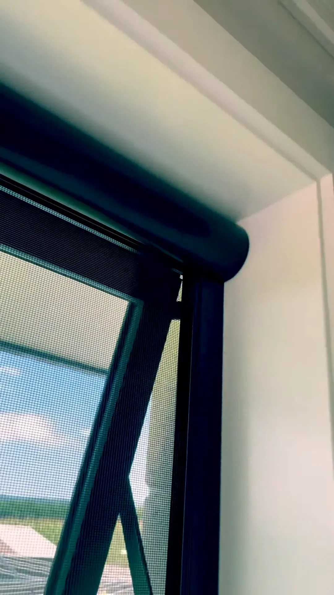 Black Serene retractable screen lowered over an open awning window